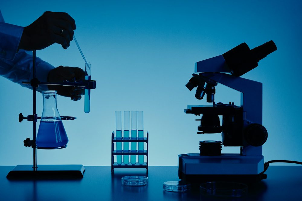A microscope and test tubes on a lab bench, evoking the UAT feedback testing window for Diamond 2